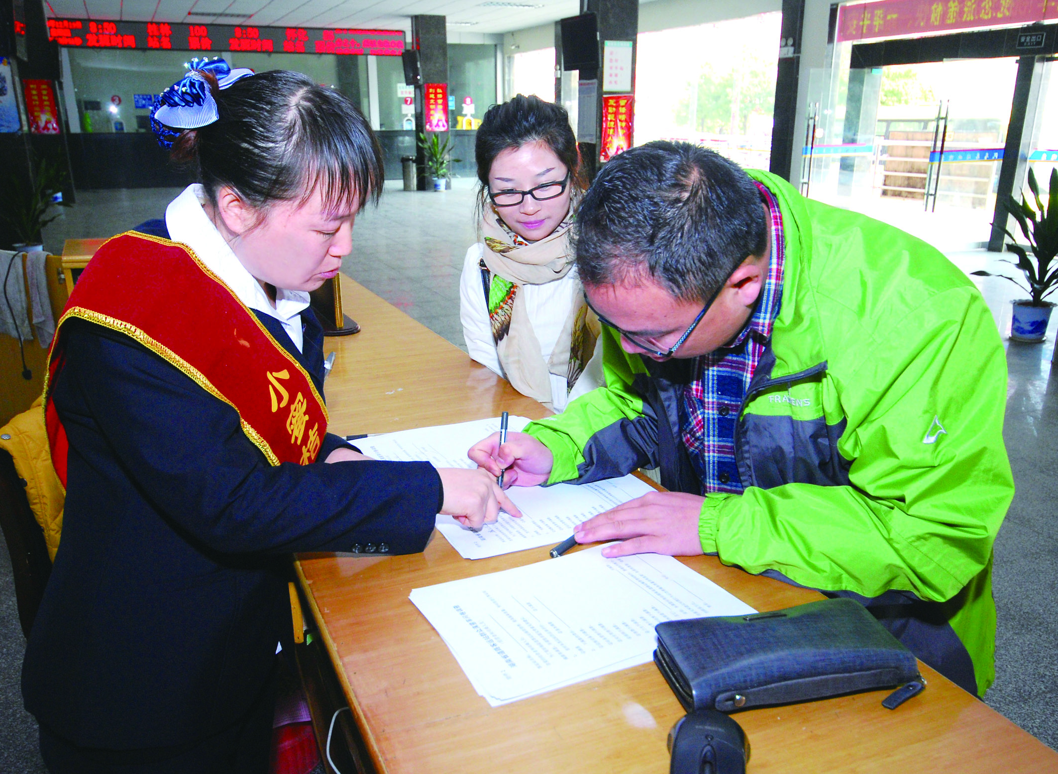 圖為洞口汽車總站站務人員在熱心為旅客服務。