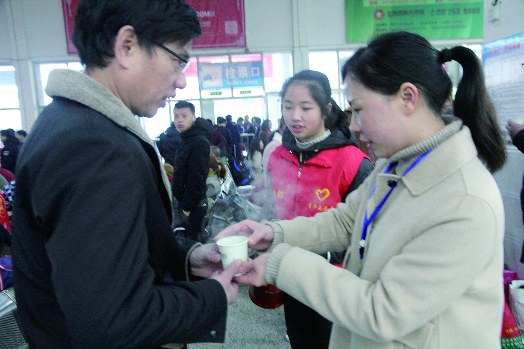 母女服務(wù)春運 2月13日，記者在新邵分公司汽車站看到，該分公司安全科副科長李喜梅與其在新邵一中初中部1701班就讀女兒劉嘉怡在車站擔(dān)當志愿者。李喜梅在候車室耐心為旅客釋疑解惑，劉嘉怡為旅客遞上一杯杯熱茶，有時母女也相互合作，其樂融融。 祖冠 攝影報道